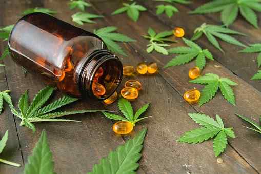 CBD Capsules scattered around a bottle